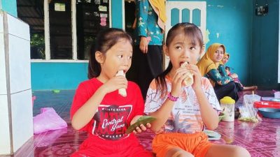 Anak-anak Desa Plajan menikmati cemilan ender