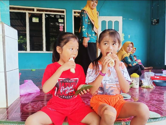 Anak-anak Desa Plajan menikmati cemilan ender