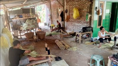 Pengrajin sapu sedang membuat sapu hamada