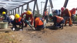 Petugas dari Dinas PUPR Kudus sedang melakukan perbaikan jembatan kencing