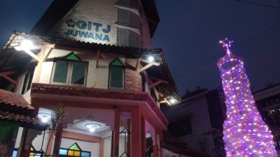 Pohon Natal setinggi delapan meter yang terbuat dari susunan ribuan botol plastik bekas dihiasi lampu di halaman Gereja Injil Tanah Jawa (GITJ) Juwana, Pati