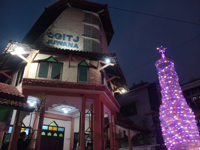 Pohon Natal setinggi delapan meter yang terbuat dari susunan ribuan botol plastik bekas dihiasi lampu di halaman Gereja Injil Tanah Jawa (GITJ) Juwana, Pati