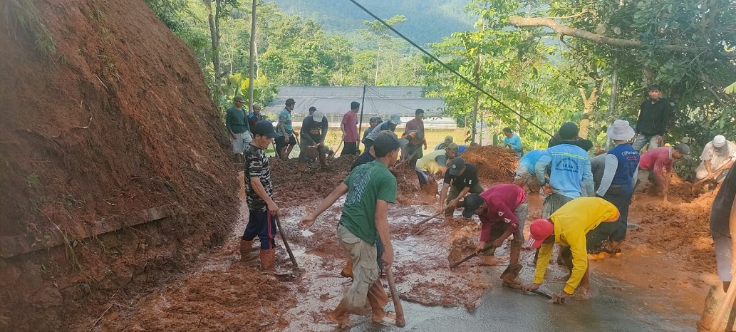 Warga dan anggota TNI bergotong royong membersihkan material longsor yang menutup jalan di Desa Tambi Pemalang