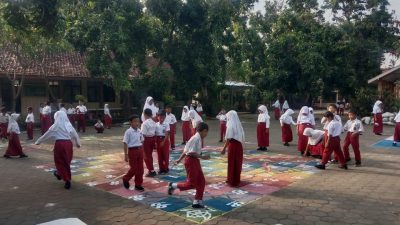 Siswa SD 4 Besito Kudus sedang asyik bermain engklek dan ular tangga di halaman sekolah yang telah dicat warna-warni.