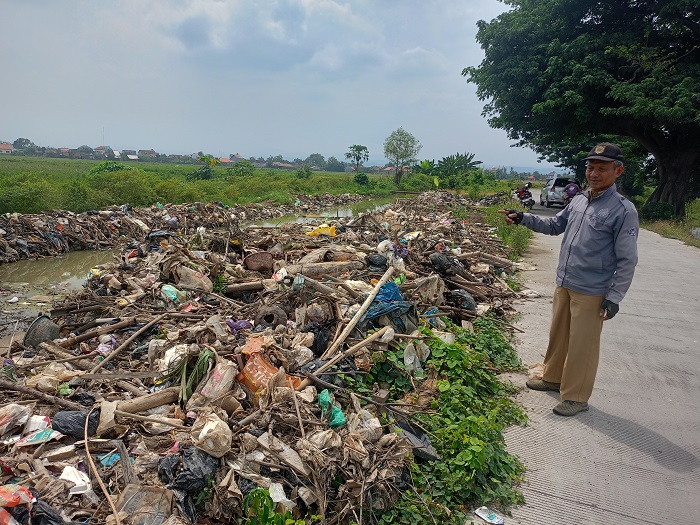 Tumpukan sampah kiriman setinggi satu meter memenuhi aliran sungai irigasi di Desa Turunrejo, Kenda