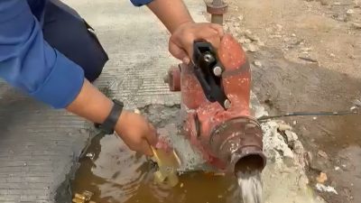 Petugas saat mengecek hidran tertimbun material cor akibat proyek perbaikan jalan di Jalan Majapahit