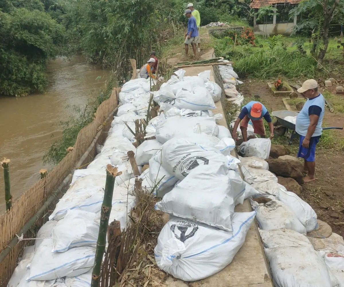 Petugas PUPR Jepara melakukan penanganan darurat pada tanggul sungai yang jebol di Kecamatan Keling menggunakan karung sak dan bambu.