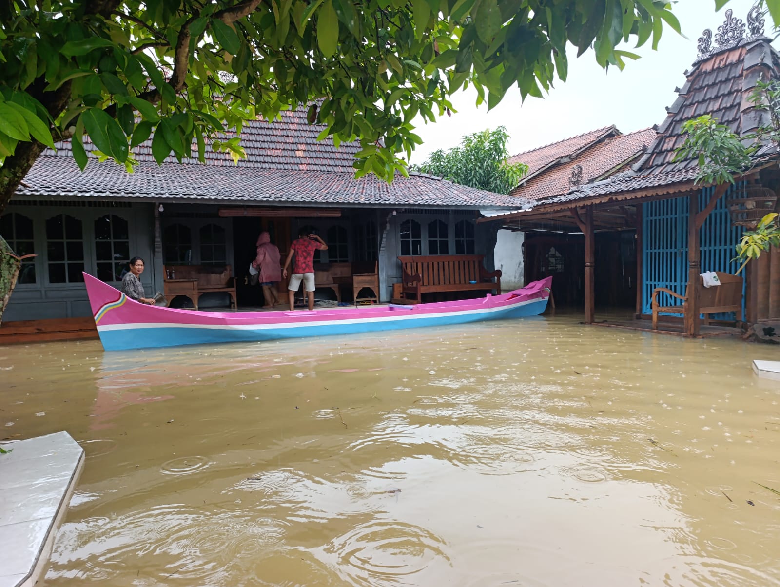 Warga Desa Mintobasuki menggunakan perahu untuk beraktivitas di tengah banjir yang merendam permukiman