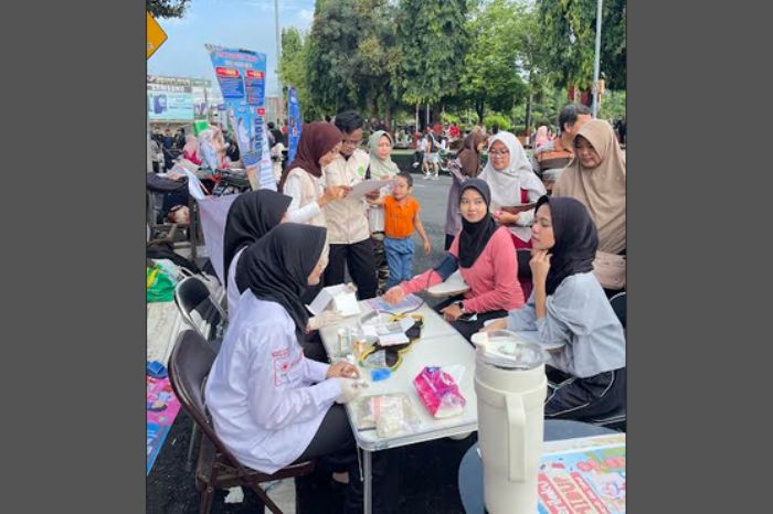Mahasiswa ITEKES Cendekia Utama Kudus sedang melayani pemeriksaan tekanan darah warga di acara Car Free Day Alun-Alun Kudus