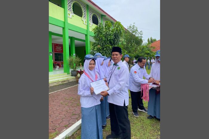 Kepala MAN Pemalang Amaludin saat menyerahkan prestasi kepada salah satu siswi,