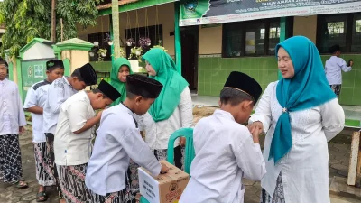 Siswa MI NU Salafiyah saat menyerahkan donasi banjir kepada perwakilan NU Peduli Jekulo.