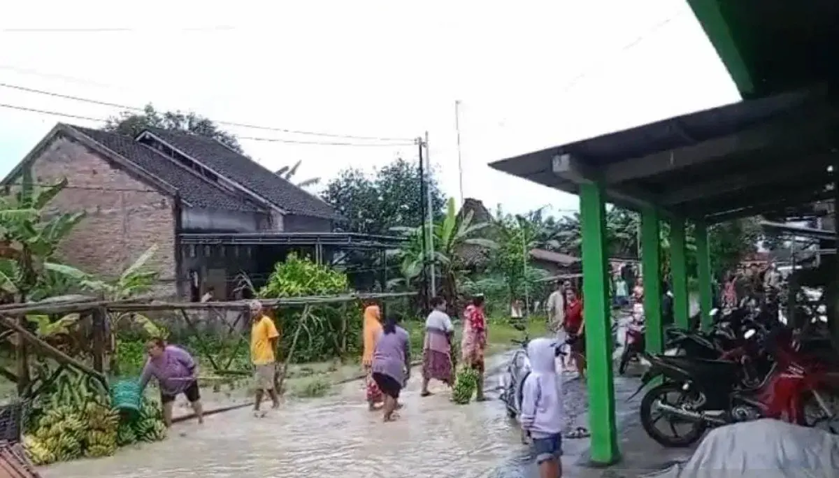 Warga menerjang genangan air saat peristiwa Banjir Grobogan yang merendam permukiman akibat luapan sungai.