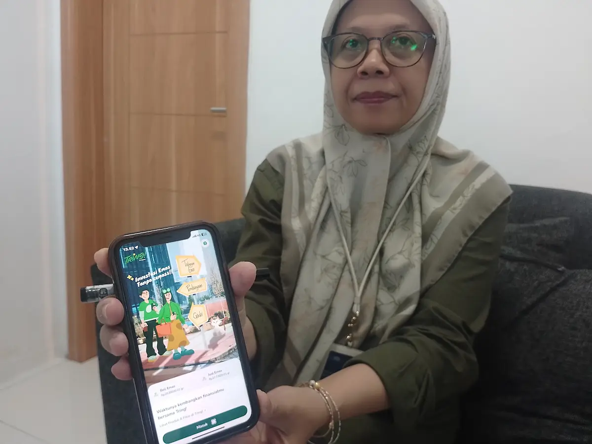 Pemimpin Cabang Pegadaian Kudus Endang Sulastri menunjukkan antarmuka aplikasi Tring Pegadaian di layar ponsel untuk mudahkan nasabah berinvestasi emas.