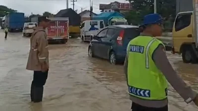 Anggota Polres Pemalang mengatur lalu lintas dan membantu pengendara di tengah Banjir Pantura Pemalang.
