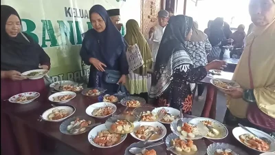 Suasana ribuan warga dan jamaah saat menikmati hidangan lontong opor gratis dalam peringatan Haul Wali Gembyang di Kabupaten Kendal.