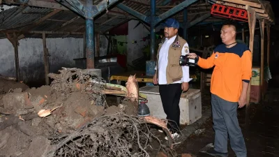 Bupati Pemalang Anom Widiyantoro sedang meninjau petugas yang menyingkirkan batang pohon tumbang yang menutupi akses Jalan Pemalang-Bantarbolang akibat hujan badai.