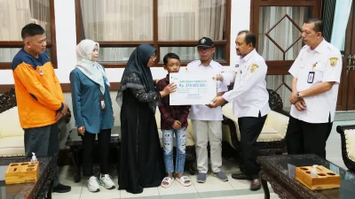 Bupati Pemalang Anom Widiyantoro menyerahkan papan simbolis santunan BPJS Ketenagakerjaan kepada keluarga almarhum korban tanah longsor.