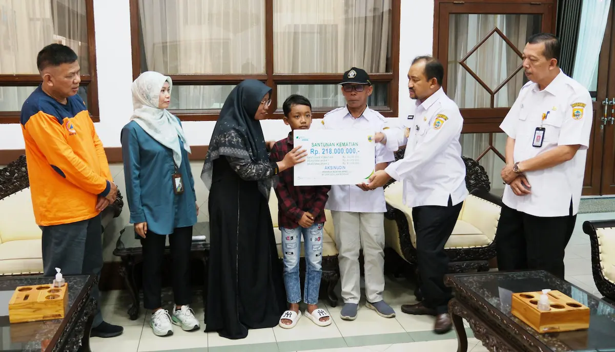 Bupati Pemalang Anom Widiyantoro menyerahkan papan simbolis santunan BPJS Ketenagakerjaan kepada keluarga almarhum korban tanah longsor.