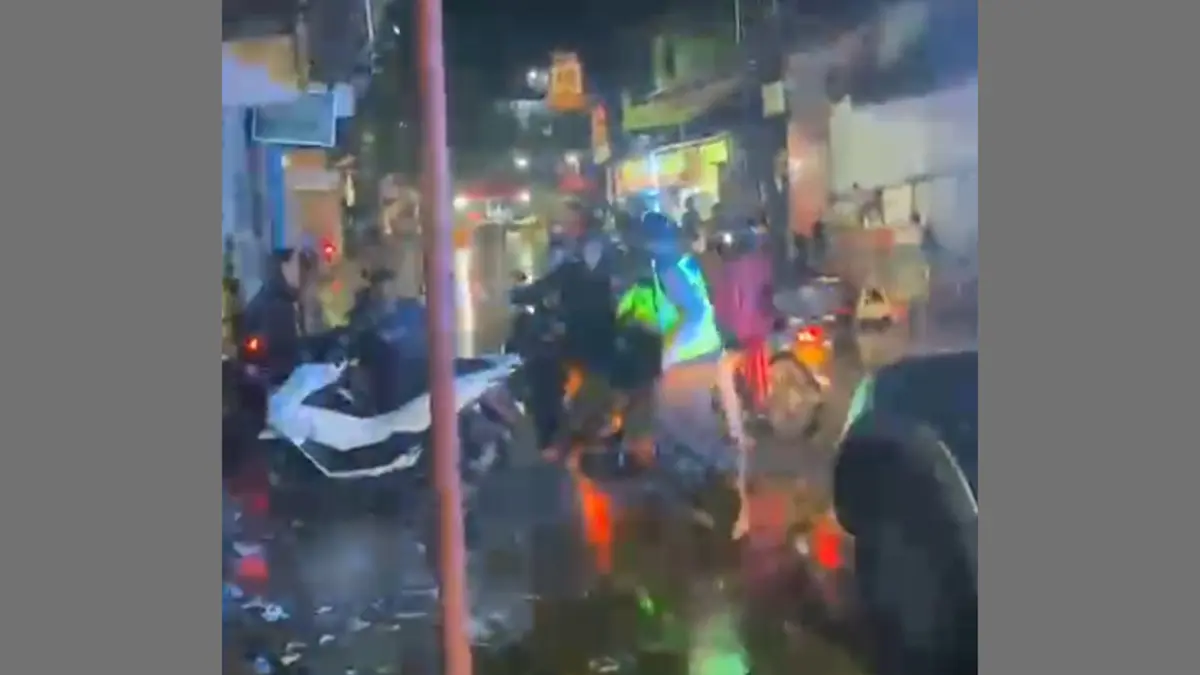 Rekaman kamera ponsel yang buram memperlihatkan keributan saat Kapolsek Kaliwungu dikerubungi dan dikeroyok oleh pemuda di tengah jalan pada malam hari.