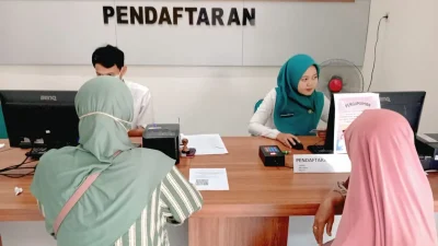 Suasana pelayanan di Puskesmas Bae Kudus di mana petugas sedang melayani warga yang mengurus pengaktifan BPJS Kesehatan.