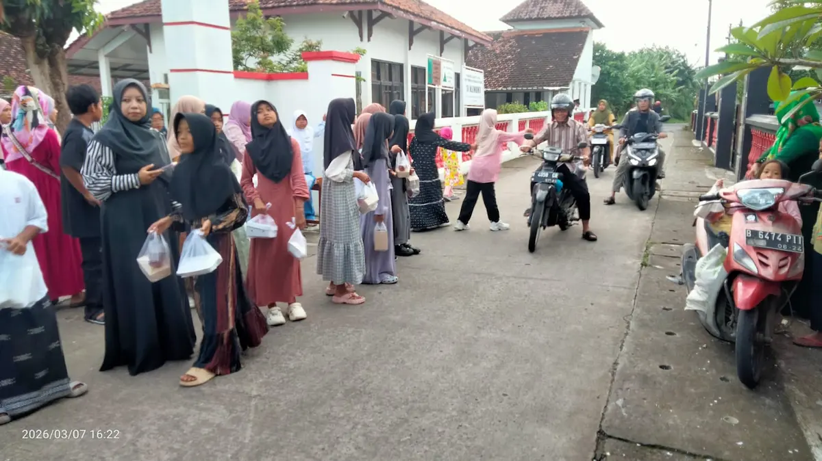 Siswa-siswi SD 1 Mlatinorowito sedang membagikan paket takjil kepada pengendara di pinggir jalan pada bulan Ramadan.