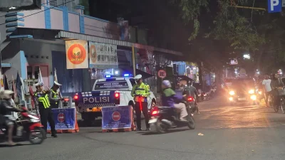 Anggota kepolisian Satlantas Polresta Pati sedang mengatur kepadatan arus lalu lintas di persimpangan jalan saat masa libur Lebaran.