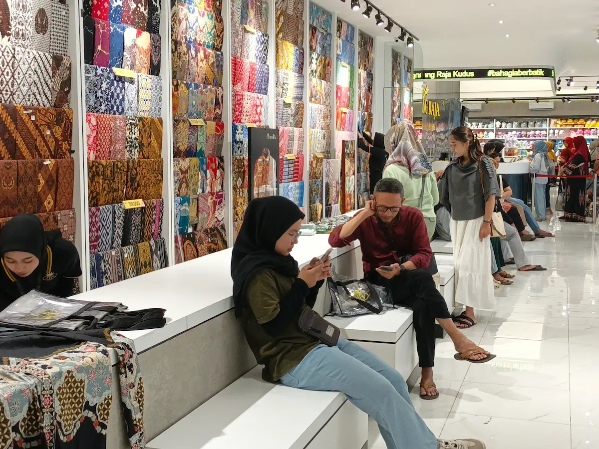 Suasana wisatawan dan pemudik berbelanja pakaian di toko Batik Benang Raja Kudus menjelang Lebaran.