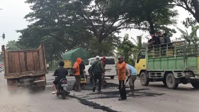 pekerja sedang melakukan pengaspalan perbaikan jalan nasional di jalur Pantura Pati hingga Rembang.
