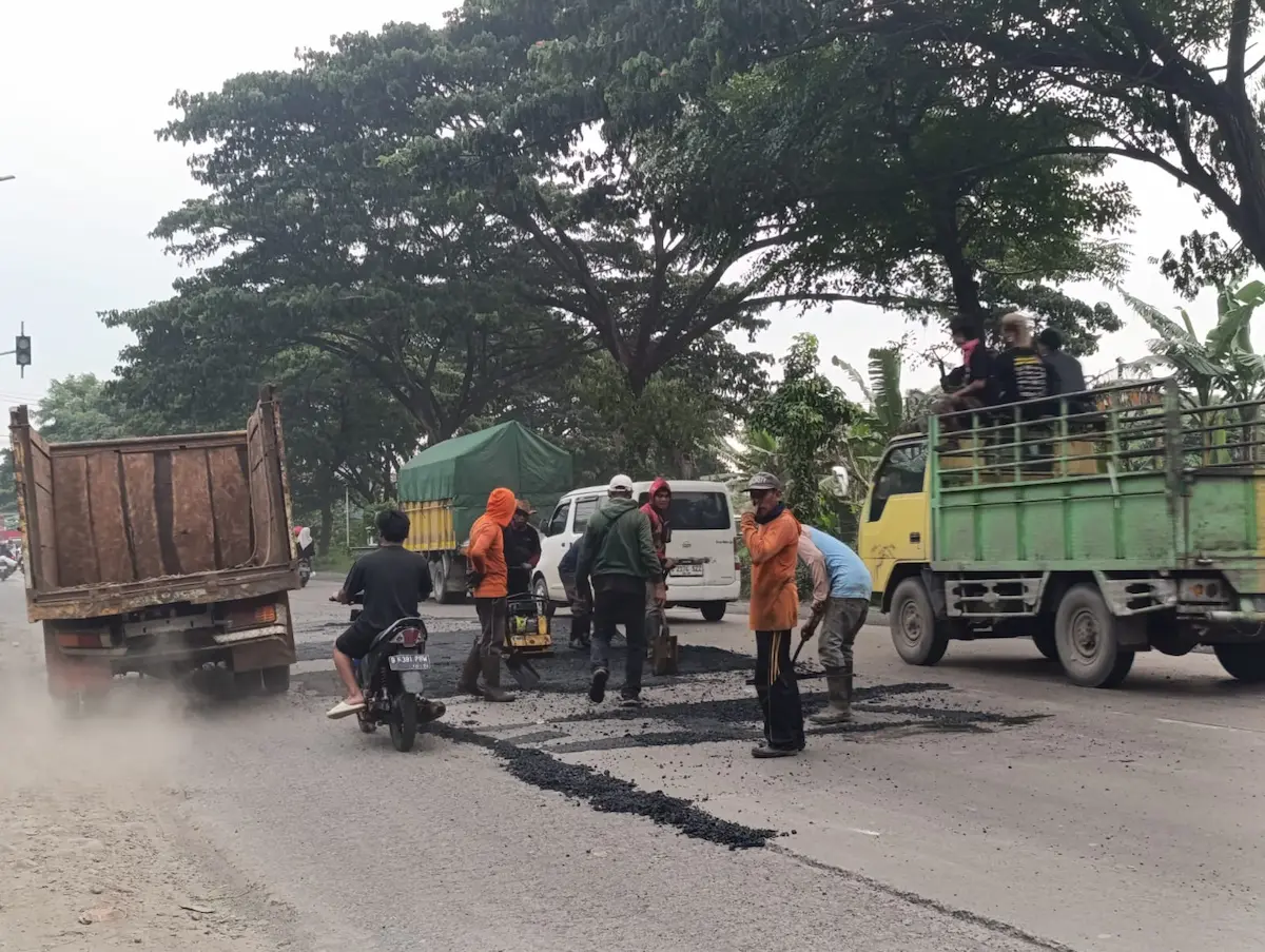 pekerja sedang melakukan pengaspalan perbaikan jalan nasional di jalur Pantura Pati hingga Rembang.